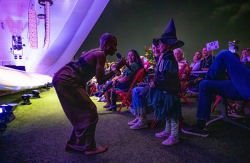 woman bending down to speak with young girl in witch's costume